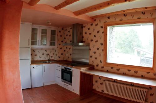 a kitchen with white appliances and a window at CHECK-IN CASAS Borda Blaner in Villanova