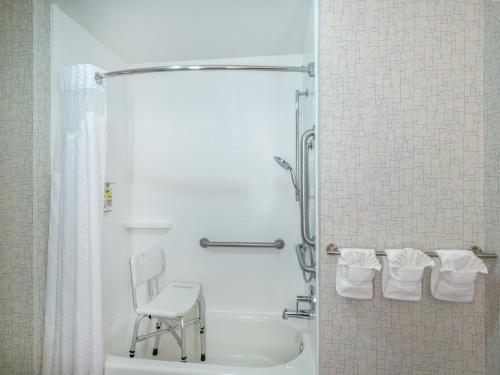 a bathroom with a shower and a chair in it at Holiday Inn Express Gas City, an IHG Hotel in Gas City