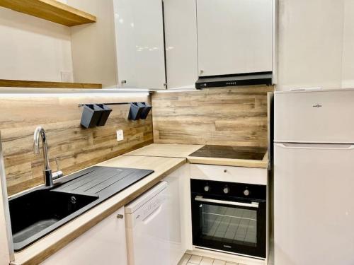 a small kitchen with a sink and a refrigerator at Magnifique Studio - 36m2 - tout équipé in Courcouronnes