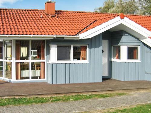 ein kleines blaues Haus mit orangefarbenem Dach in der Unterkunft 6 person holiday home in Otterndorf in Otterndorf