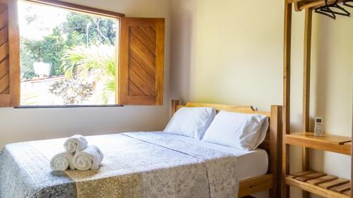 a bedroom with a bed with towels on it at Flats Brasil Itacaré in Itacaré