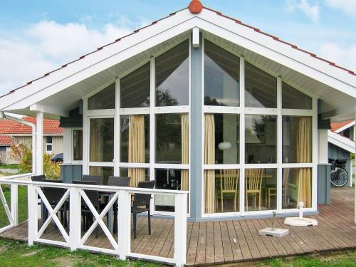 un pavillon avec de grandes portes en verre sur une terrasse dans l'établissement 6 person holiday home in Otterndorf, à Otterndorf