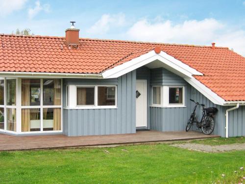 a small blue house with an orange roof at 6 person holiday home in Otterndorf in Otterndorf