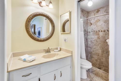 a bathroom with a sink and a toilet and a mirror at Sea Shell 24 in Clearwater Beach