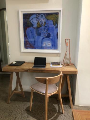 a wooden desk with a laptop and a chair at 1 The Eighteenth, Prince’s Grant Golf Estate in Blythedale