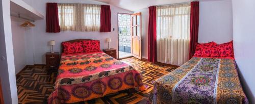 1 dormitorio con 2 camas y cortinas rojas en Casa de campo Villa Acosta, en Los Baños del Inca