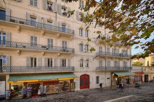un immeuble avec balcons sur une rue avec un magasin dans l'établissement REF 1393 - Cannes Center - Apartment for rent, à Cannes