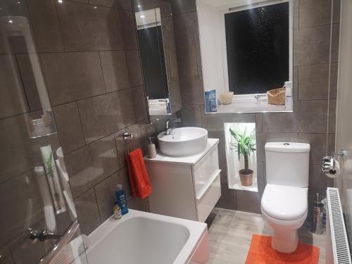 uma casa de banho com um WC branco e um lavatório. em Cosy double room in peaceful location, Ballachulish nr Glencoe Highlands em Ballachulish