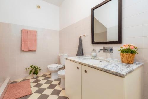 a bathroom with a sink and a toilet and a mirror at Female Hostel in Faro