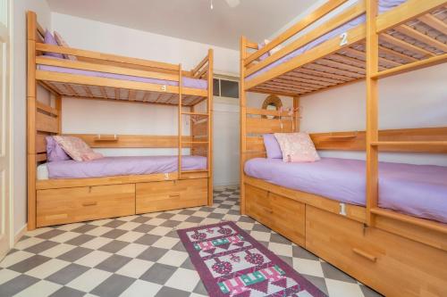 2 letti a castello in una camera con pavimento a scacchi di Female Hostel a Faro