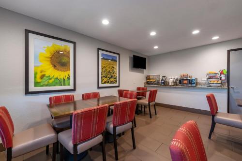 a restaurant with a table and chairs and a sunflower painting at Comfort Inn & Suites Hays I-70 in Hays