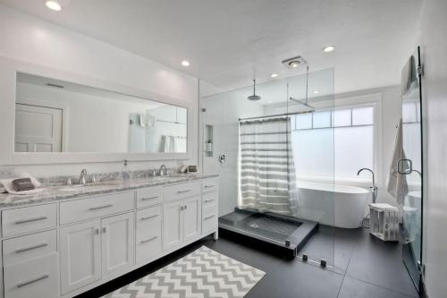a bathroom with two sinks and a tub and a shower at Luxury Ocean Views & Steps To The Sand - Tower 36 Upper Condo Unit in Carlsbad