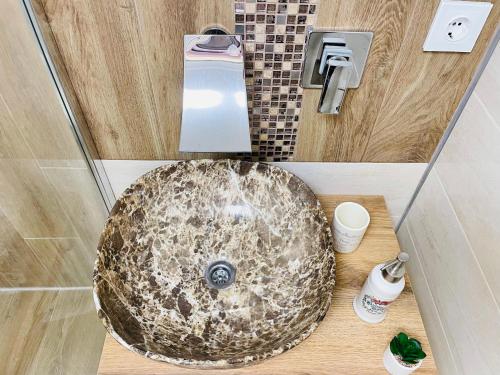 a bathroom with a granite sink in a shower at Imperium DK Apartament in Giurgiu