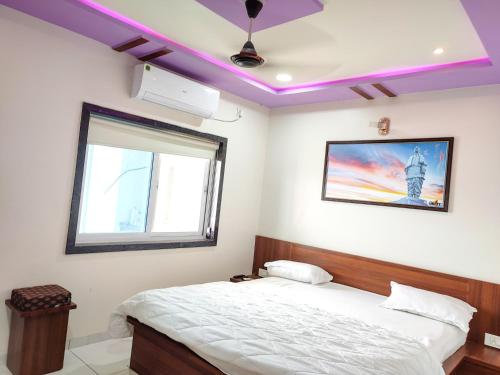 a bedroom with a bed with a purple ceiling at Hotel Sardar Rooms in Garudeshwar