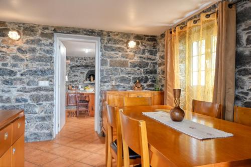 a kitchen and dining room with a stone wall at Casa do Pombal, a Home in Madeira in Arco da Calheta