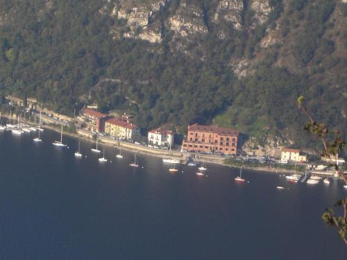 a group of boats in the water near a town at COZY LAKE COMO APARTMENTS in Valmadrera