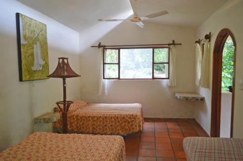 een kamer met 2 bedden en een raam bij Aventurec in Piedra Pinta