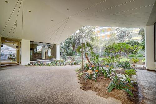 un grand bâtiment avec une cour ornée de plantes dans l'établissement REF 1389 - Cannes Center - Apartment for rent, à Cannes