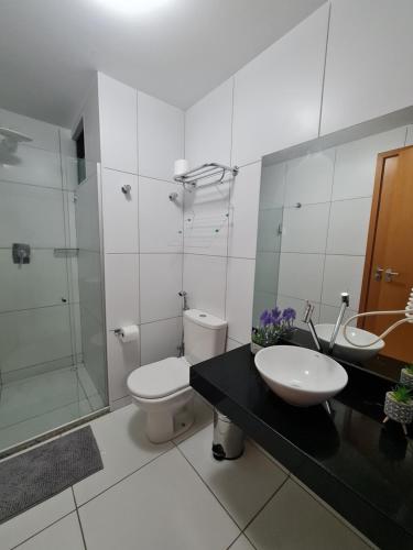 a bathroom with a toilet and a sink and a shower at ILOA Condomínio Resort Barra de São Miguel in Barra de São Miguel