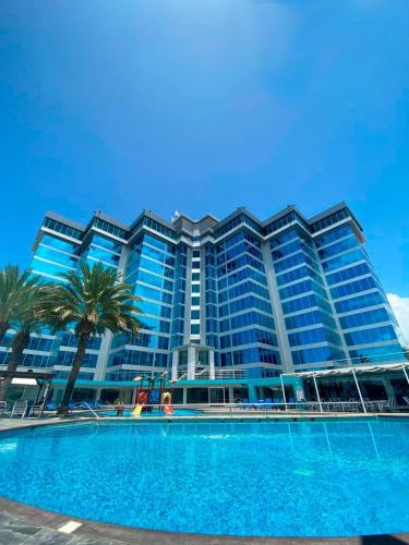 - un grand bâtiment avec une piscine en face dans l'établissement Tibisay Hotel Boutique Margarita, à Porlamar