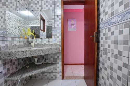 a bathroom with a pink door and a sink at Suites Palmeiras Cabo Frio in Cabo Frio