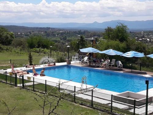 una gran piscina con gente sentada a su alrededor en Cabatanti, en Tanti