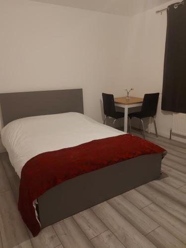 um quarto com uma cama e uma mesa com cadeiras em Aaby House in London em Croydon