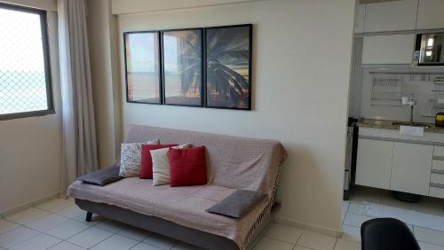 Apartamento com 2 quartos de FRENTE PARA O MAR في ماسيو: غرفة معيشة مع أريكة مع وسائد حمراء