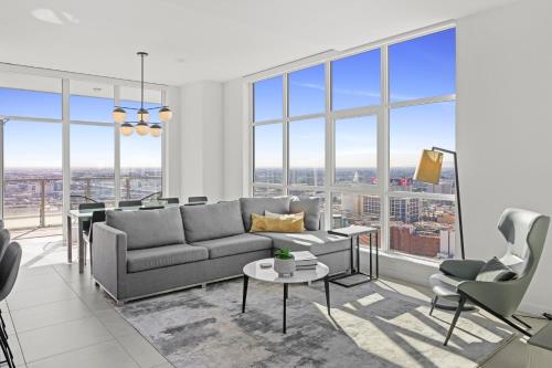a living room with a couch and chairs and windows at Level Los Angeles - Downtown Flower in Los Angeles