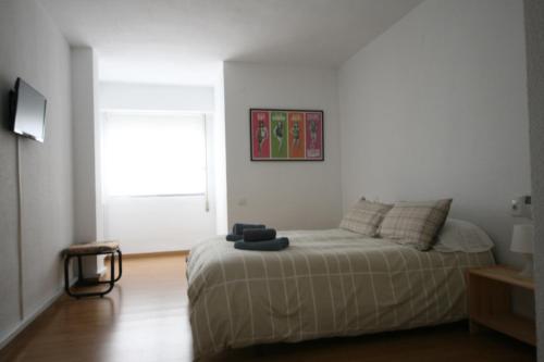 ein weißes Schlafzimmer mit einem Bett und einem Fenster in der Unterkunft Las Minvas Centro in Castellón de la Plana