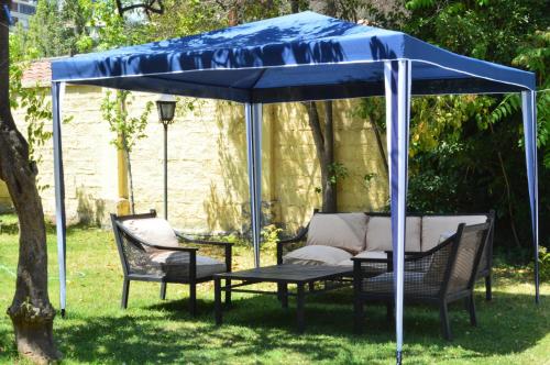 a blue canopy with chairs and a table in a yard at Olea's Home Las Condes in Santiago