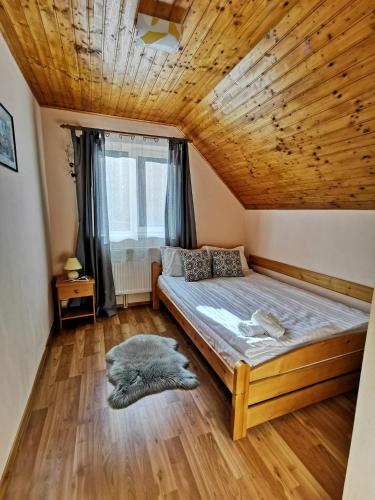 a bedroom with a bed and a wooden ceiling at Cabana Alina in Păltiniş