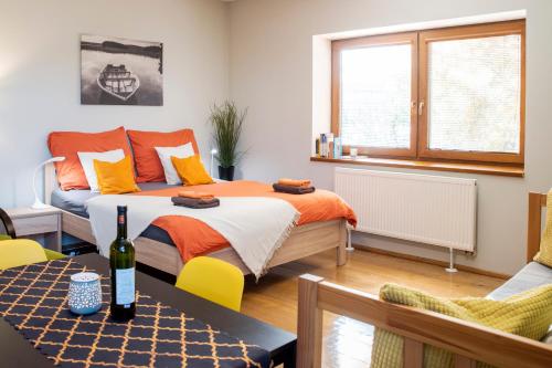 Un dormitorio con una cama y una mesa con una botella de vino en Apartmán u Horynů - Sadová, en Česká Třebová
