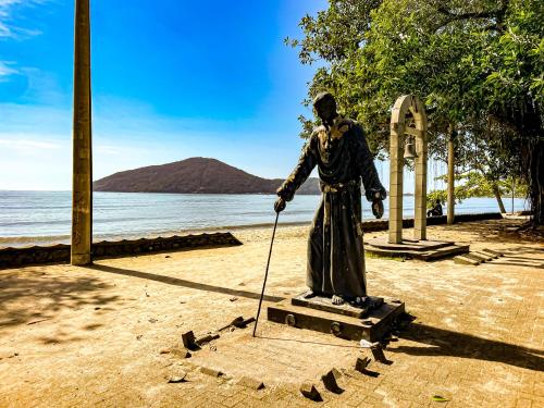 a statue of a man with a cane on a sidewalk at Hotel Parque Atlântico in Ubatuba