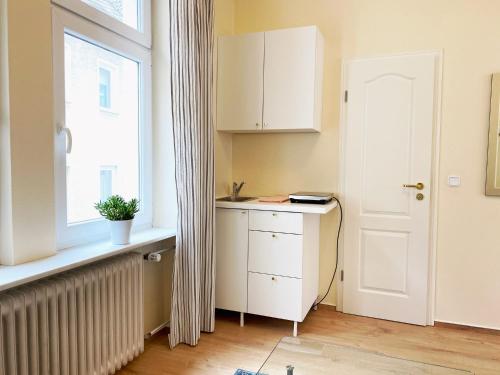 Gemütlich und Zentral in Boppard في بوبارد: مطبخ مع نافذة وخزانة بيضاء