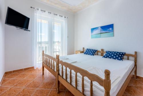 a bedroom with a bed and a flat screen tv at Apartments PERA in Selce