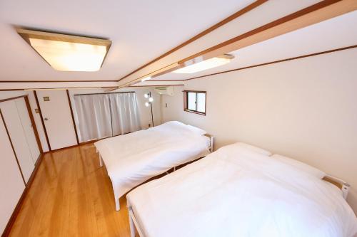 Habitación pequeña con 2 camas y suelo de madera. en Shinagawa-ku - House - Vacation STAY 13521, en Tokio
