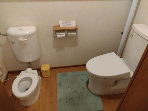 a bathroom with a white toilet and a blue rug at Daramusara - Vacation STAY 13520 in Furano
