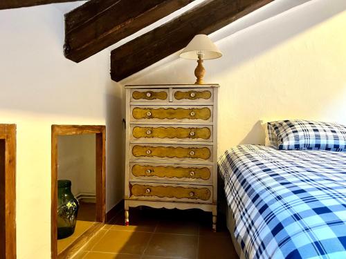 a bedroom with a dresser and a bed at ÀTIC CASA POMAR in Camprodon