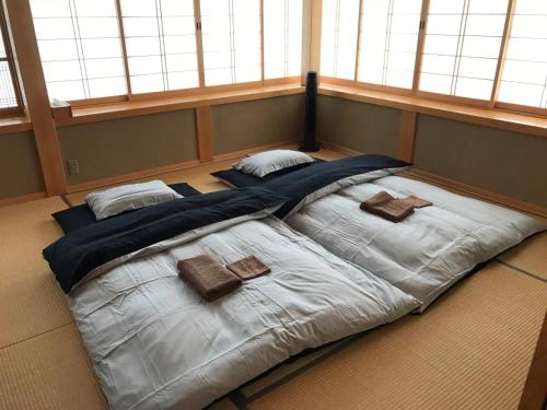 ein großes Bett in einem Zimmer mit Fenstern in der Unterkunft Villa MITORE-YA - Vacation STAY 13536 in Takayama