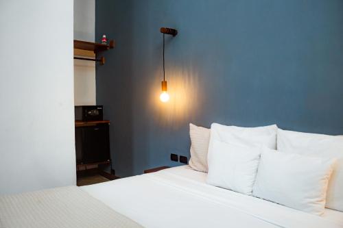 a bedroom with a white bed with white pillows at Hotel con Corazón Granada in Granada