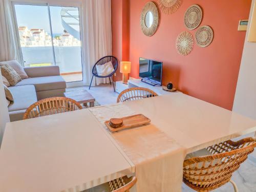 een woonkamer met een tafel en stoelen en een bank bij Seaview Penthouse Valle Romano Golf in Estepona