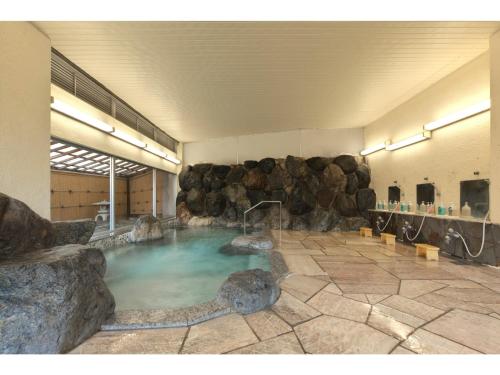 a large pool of water in a room with rocks at Kanko Hotel Yumotokan - Vacation STAY 60199v in Gero