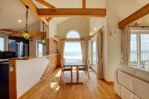 uma sala de jantar com uma mesa e algumas janelas em Costa Blanca House - Vacation STAY 62301v em Minamiboso