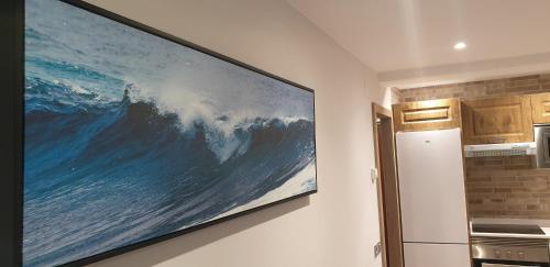 una gran pintura de una ola colgando de una pared en Apartamento Barrio de la Arena, en Gijón
