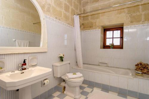 Birbuba的住宿－Ponderosa Holiday Home，白色的浴室设有水槽、卫生间和浴缸。
