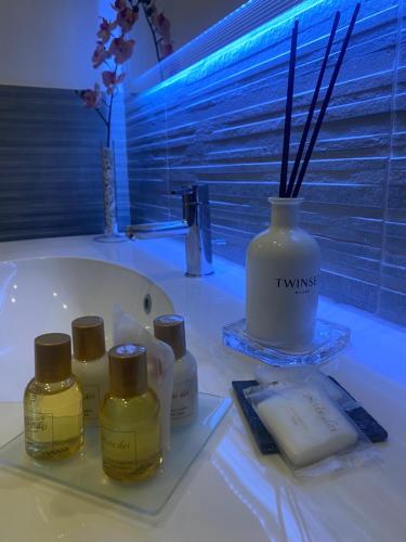 a bathroom with four bottles of soap and a bath tub at Dea Suite in Naples
