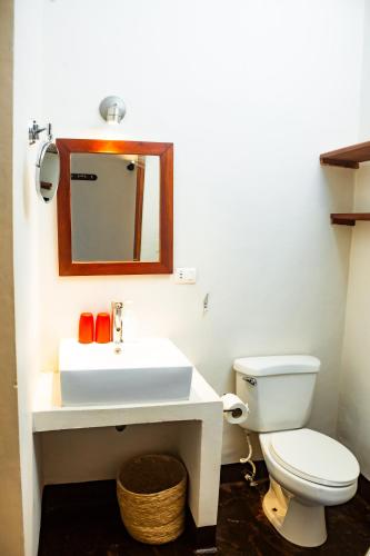 a bathroom with a white sink and a toilet at Hotel con Corazón Granada in Granada