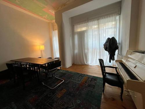a room with a piano and a table with chairs at Schönes Loft mit Kamin in Mitte Gesundbrunnen in Berlin