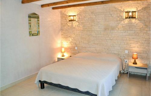 a bedroom with a white bed and a brick wall at 2 Bedroom Beautiful Home In Lolme in Lolme